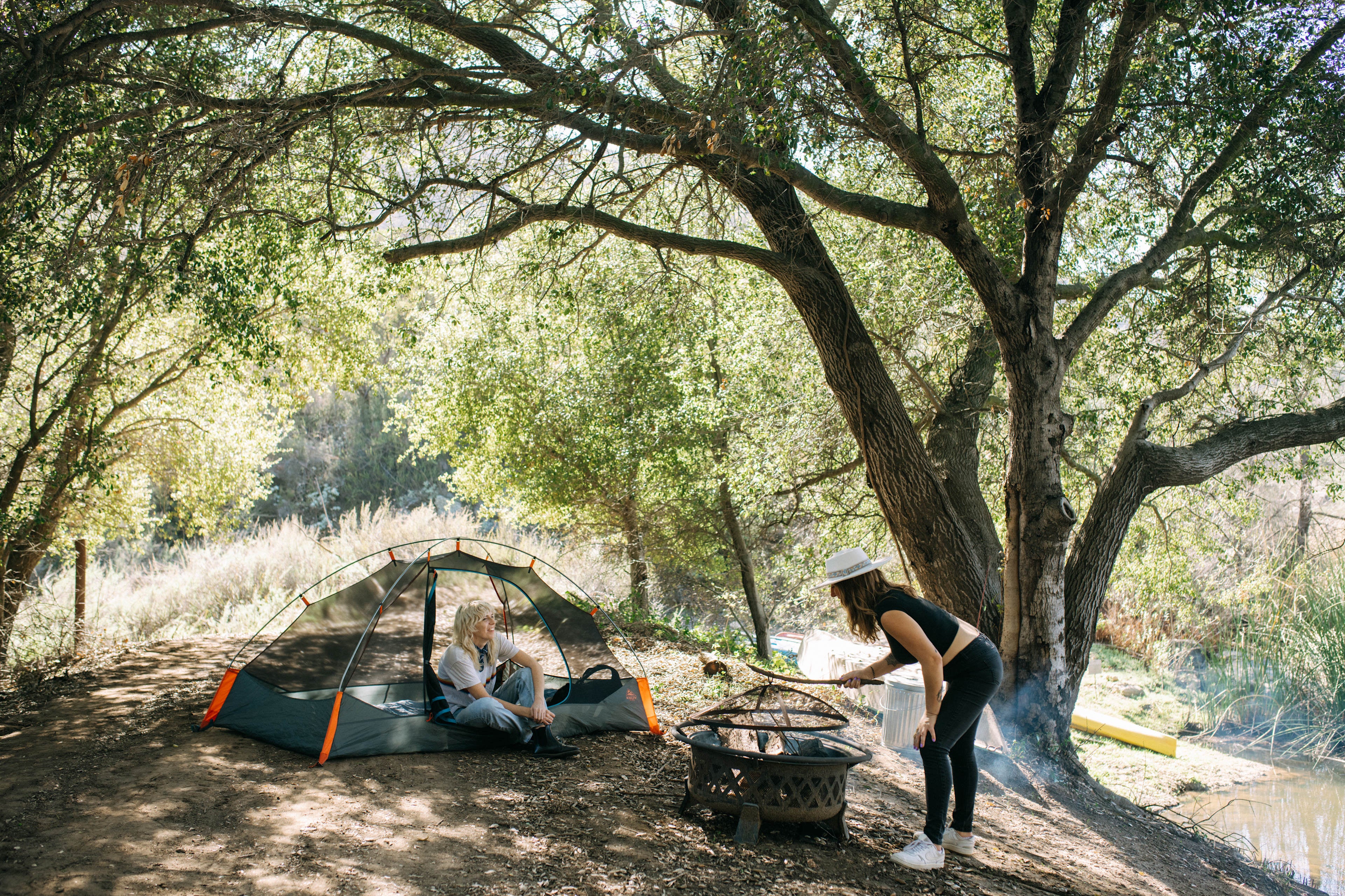 Spring camping scene with tent and campfire by the lake – LITEGUEST outdoor gear lifestyle